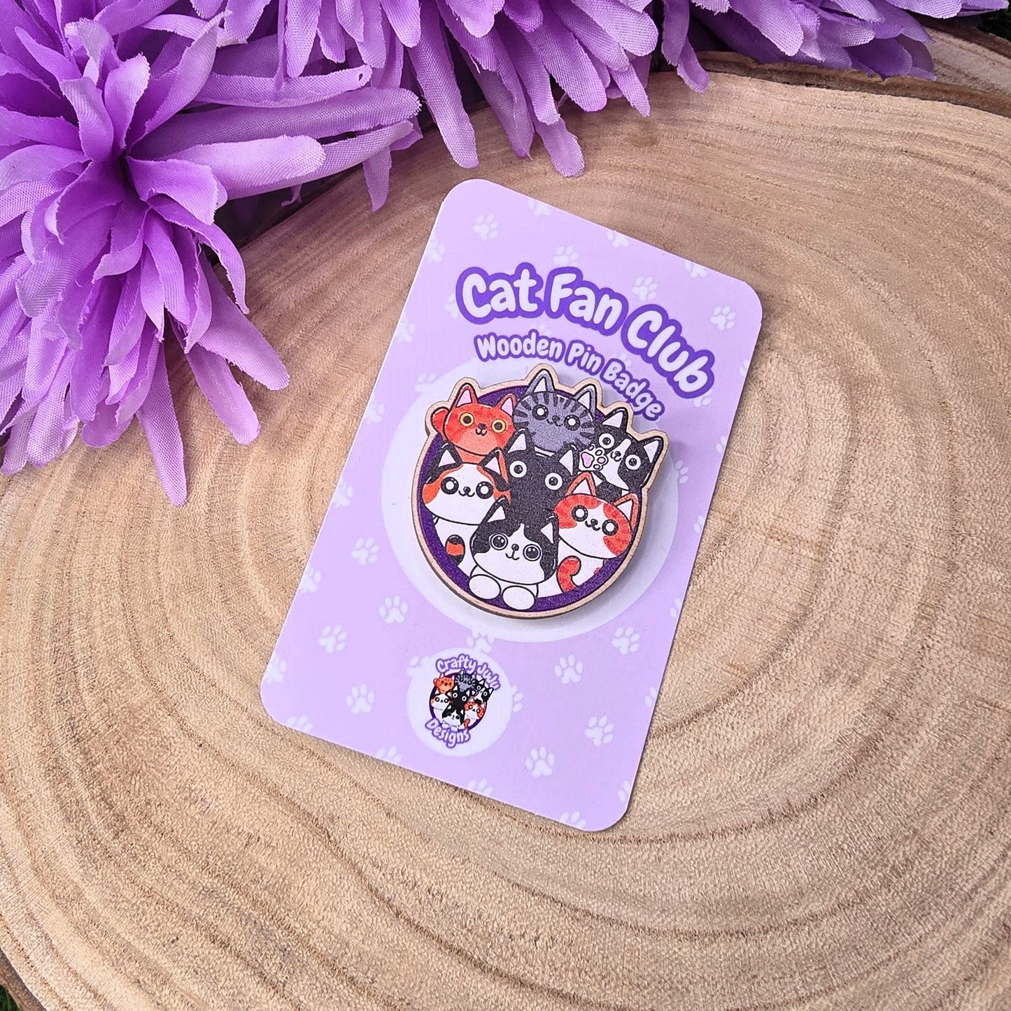 Cat-themed badge on a purple card with flowers in the background