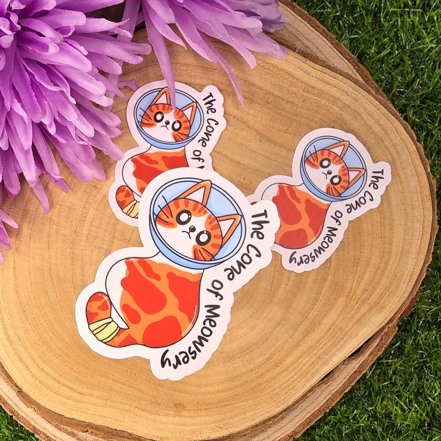 Set of stickers with a cat design on a wooden surface with purple flowers.