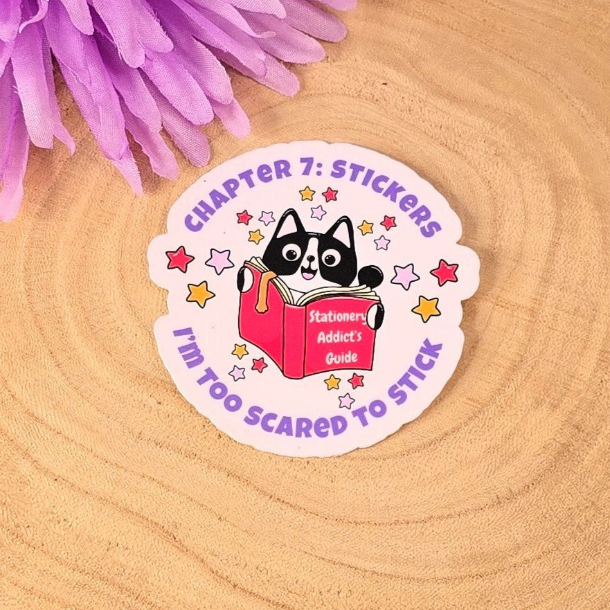 Sticker with a cat design on a wooden surface with purple flowers