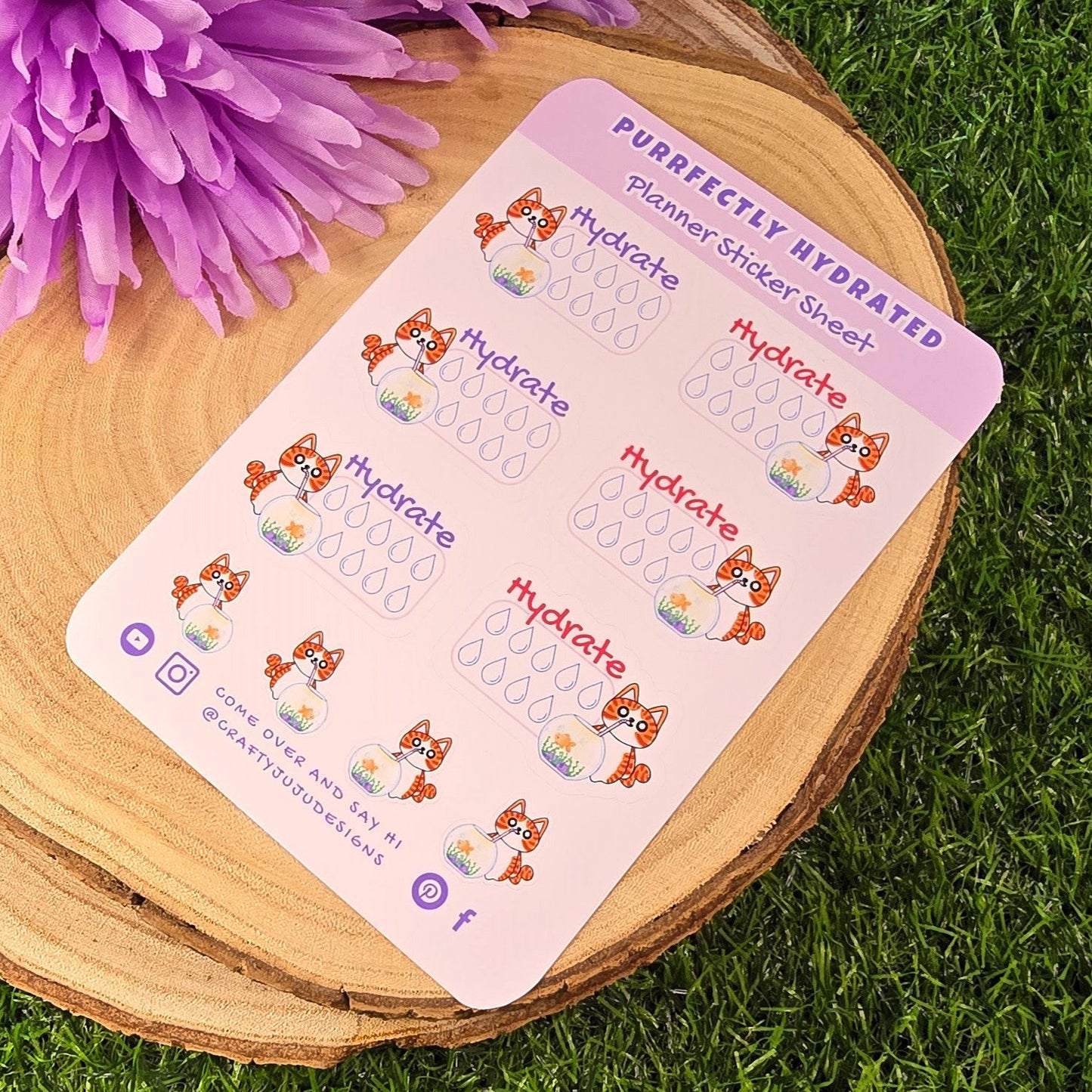 planner sticker sheet hydration reminders on a wooden surface with purple flowers and grass in the background