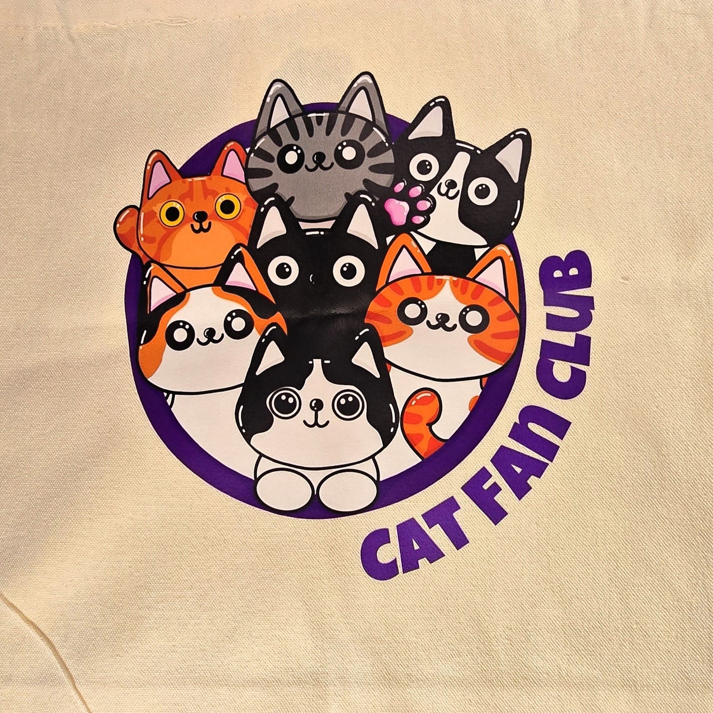 tote bag with cat-themed design on grass
