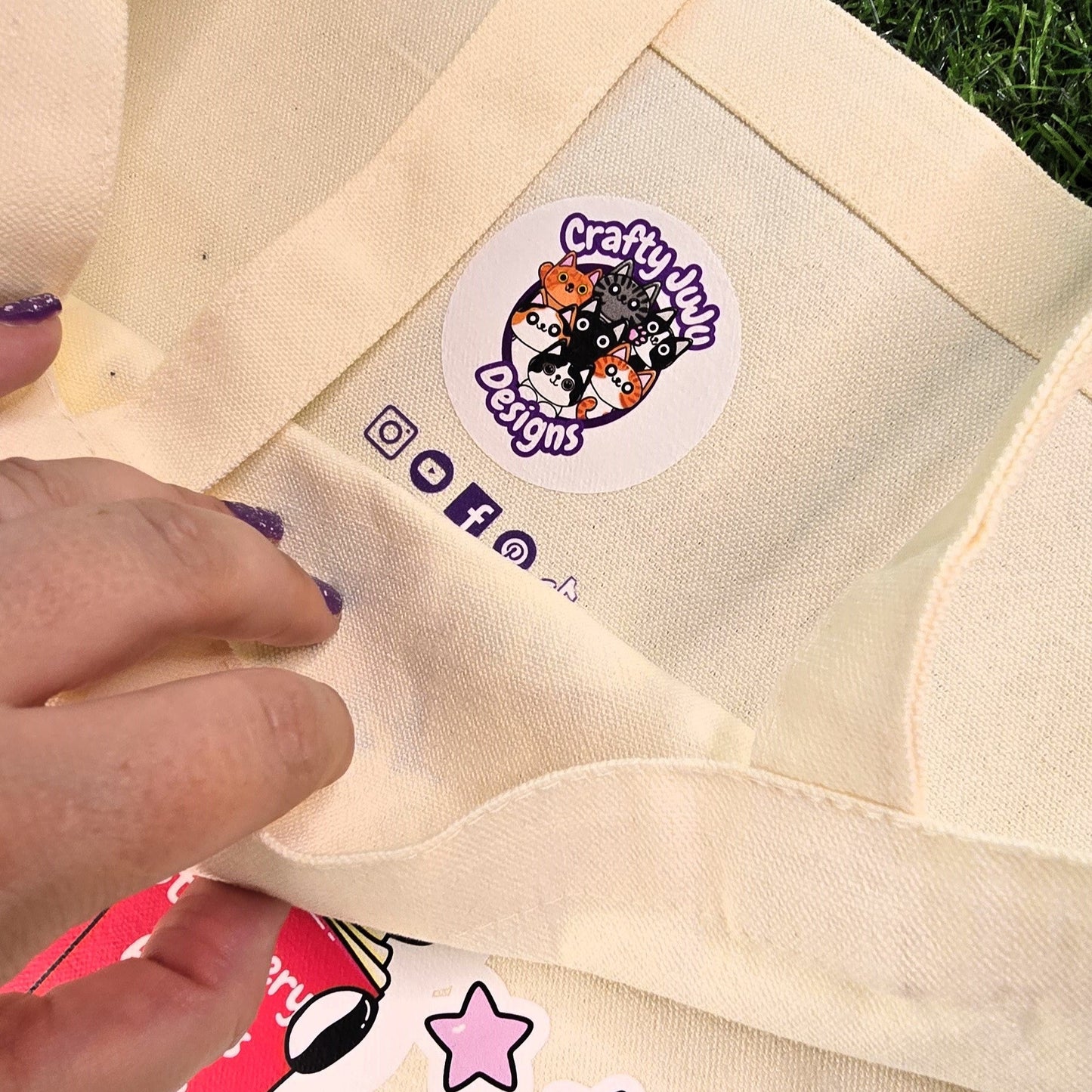 Beige tote bag with a brand label on grass