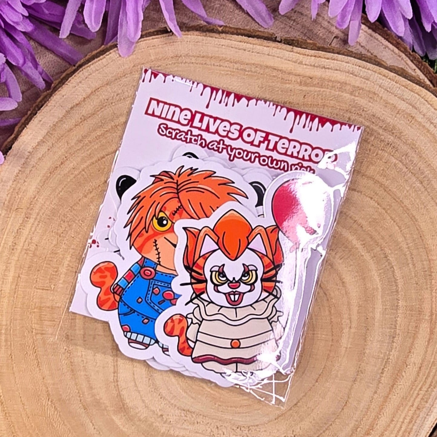 Two stickers of a clown character on a wooden surface with purple flowers in the background