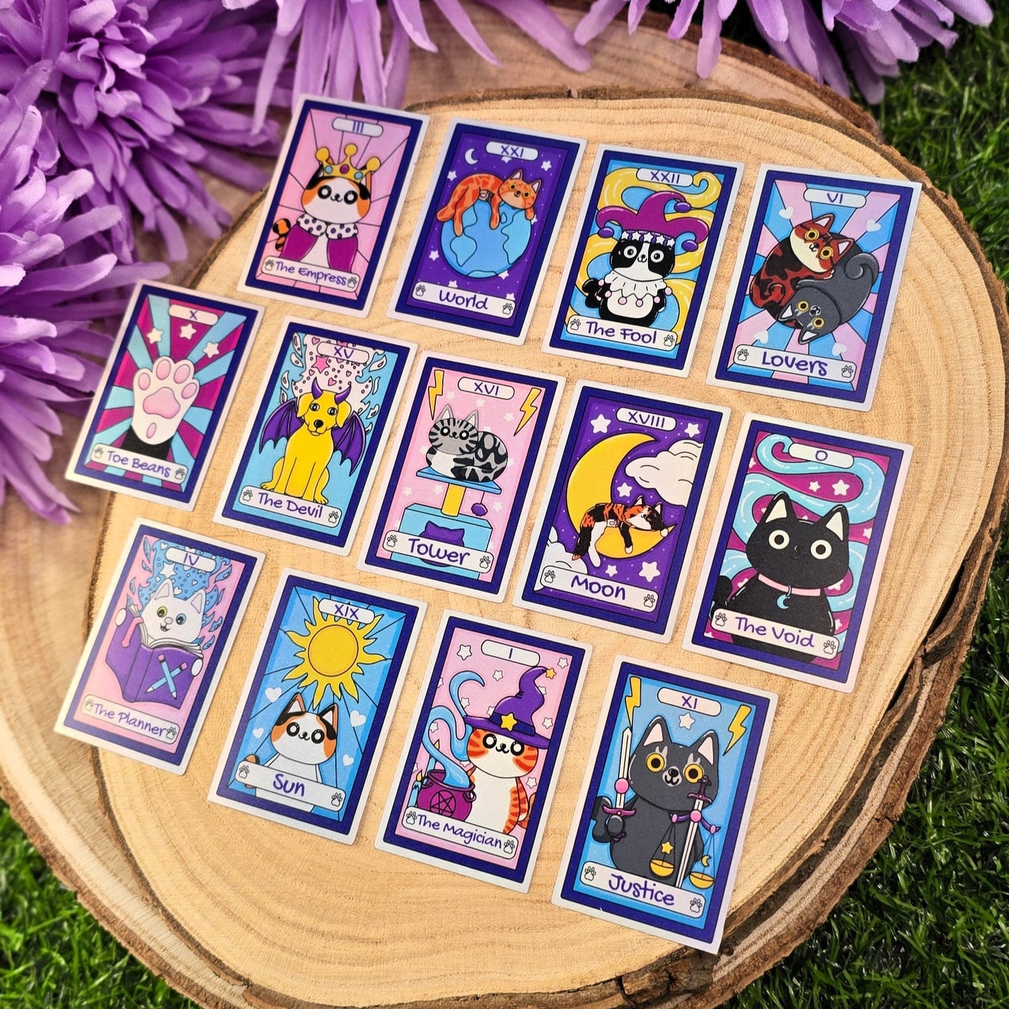Set of colorful tarot card stickers on a wooden stand with purple flowers in the background