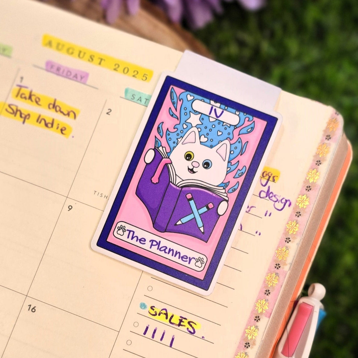 Planner with stickers and a pen on a grassy background