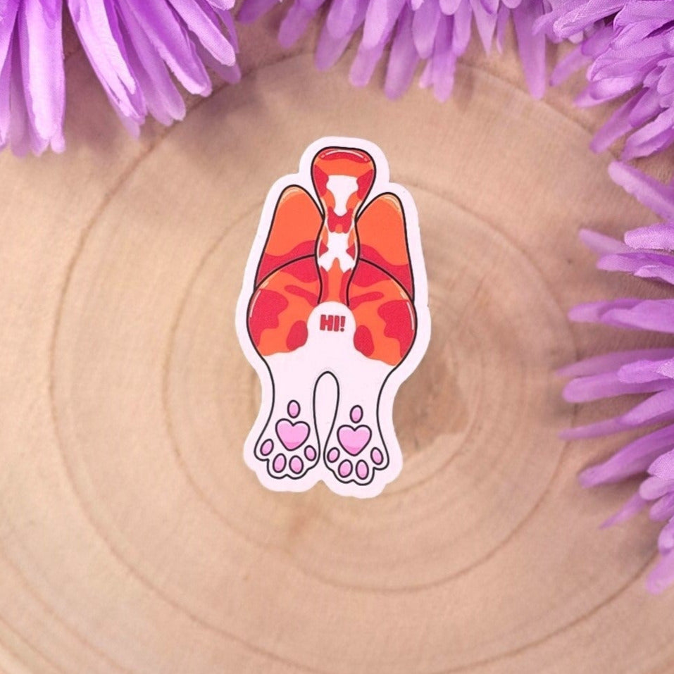 cat-shaped stickers on a wooden surface with purple flowers in the background.