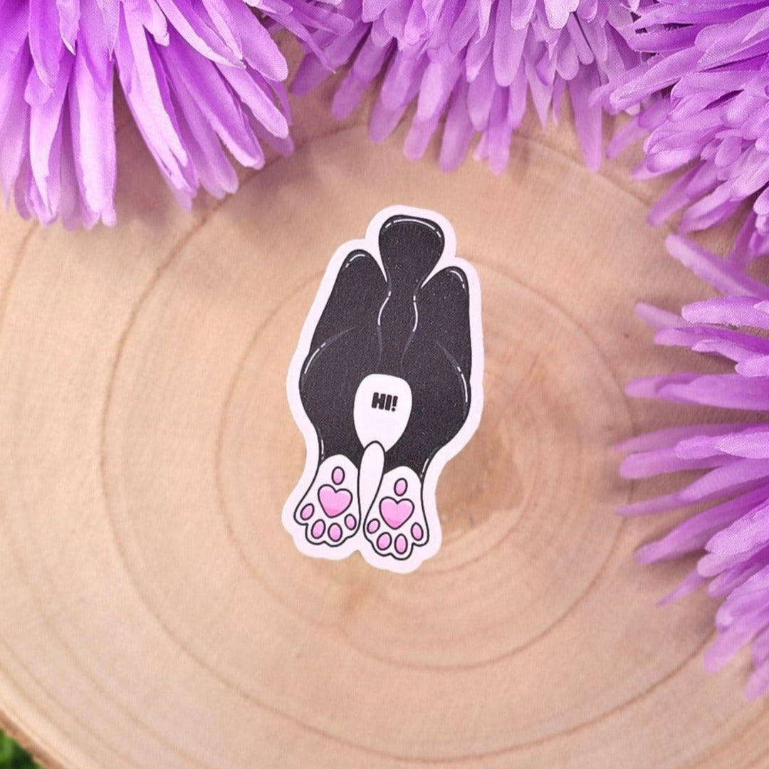 cat-shaped stickers on a wooden surface with purple flowers in the background.