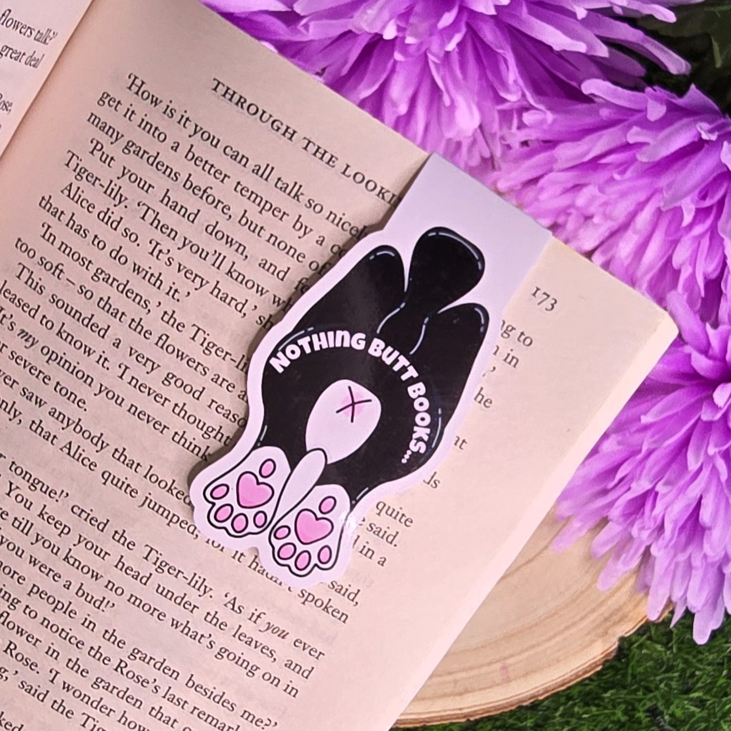 Bookmark with 'Nothing Butt Books' design on an open book with purple flowers in the background