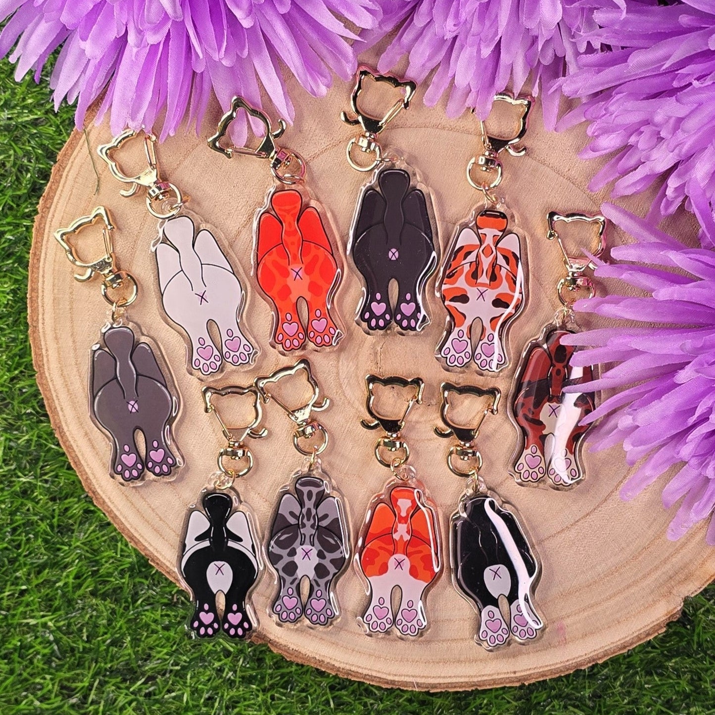 Set of colorful keychains on a wooden board with purple flowers in the background