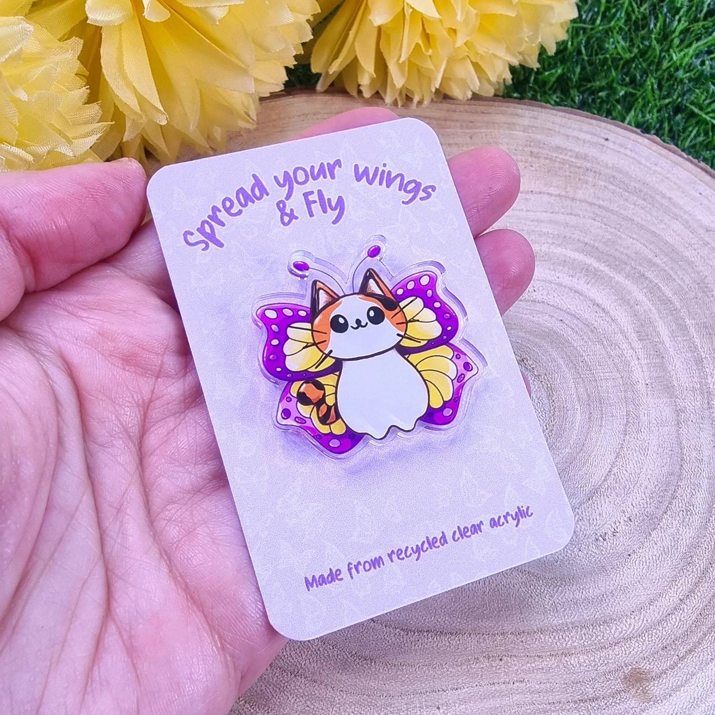 Butterfly cat illustrated pin held in hand