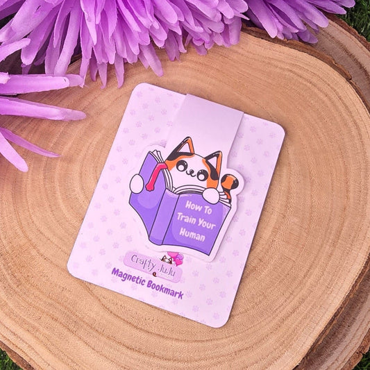 Magnetic bookmark with cartoon design on a wooden surface with purple flowers