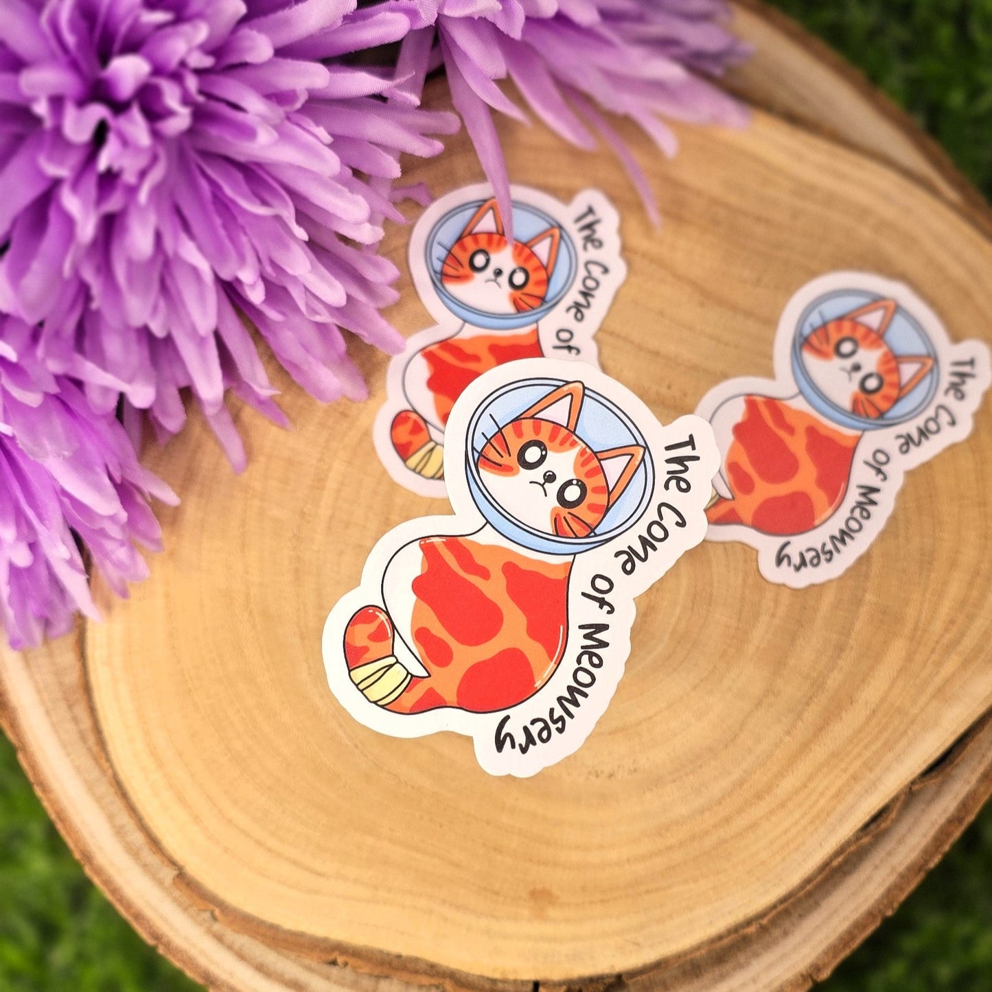 Stickers with cat designs on a wooden surface with purple flowers