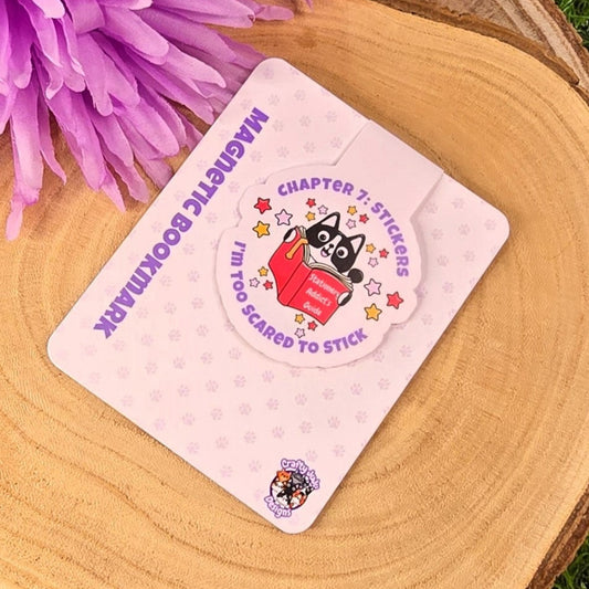 magnetic bookmark on a wooden surface with purple flowers and grass in the background