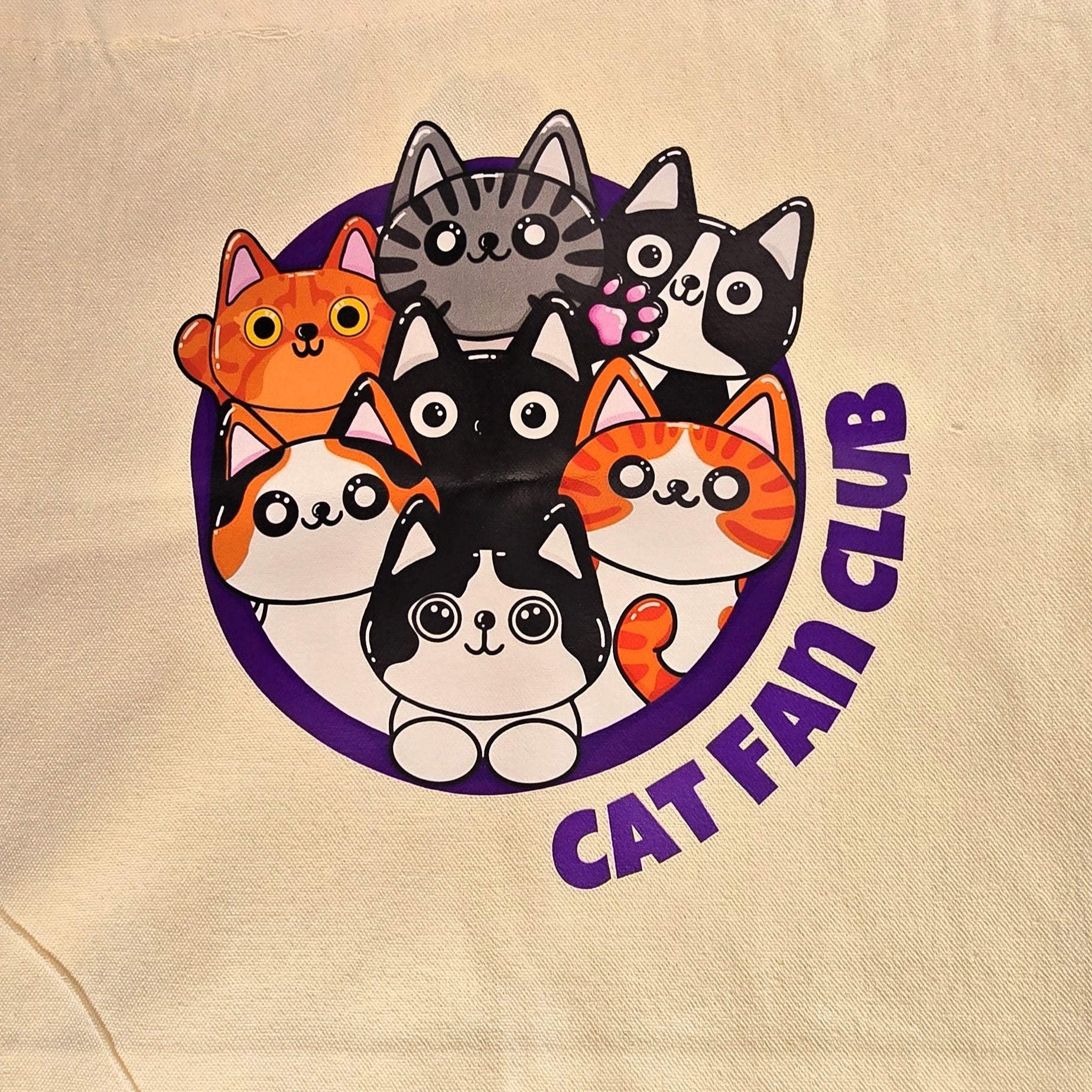 tote bag with cat-themed design on grass