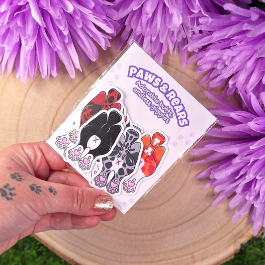 Sticker pack with cats showing off their butts illustrations on a wooden log with purple flowers in the background