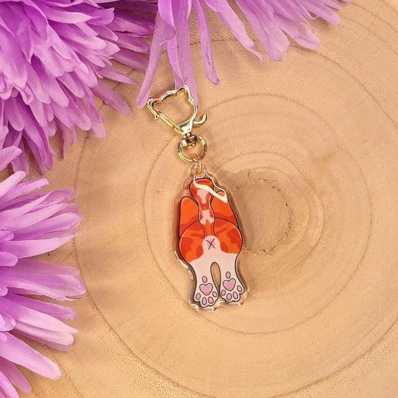 ginger and white cat butt keyring on a wooden stand 