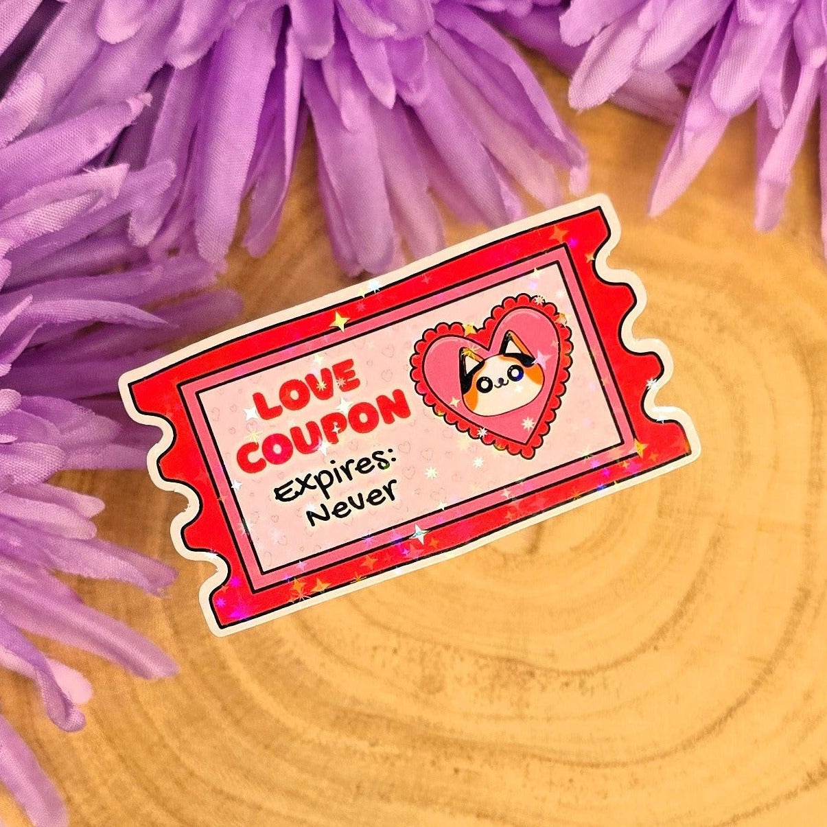 Love coupon sticker with a cat illustration on a wooden surface with purple flowers