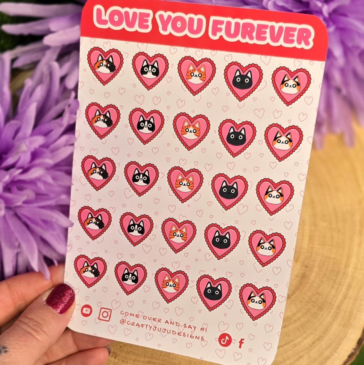 Sheet of heart-shaped stickers with cartoon characters held over purple flowers