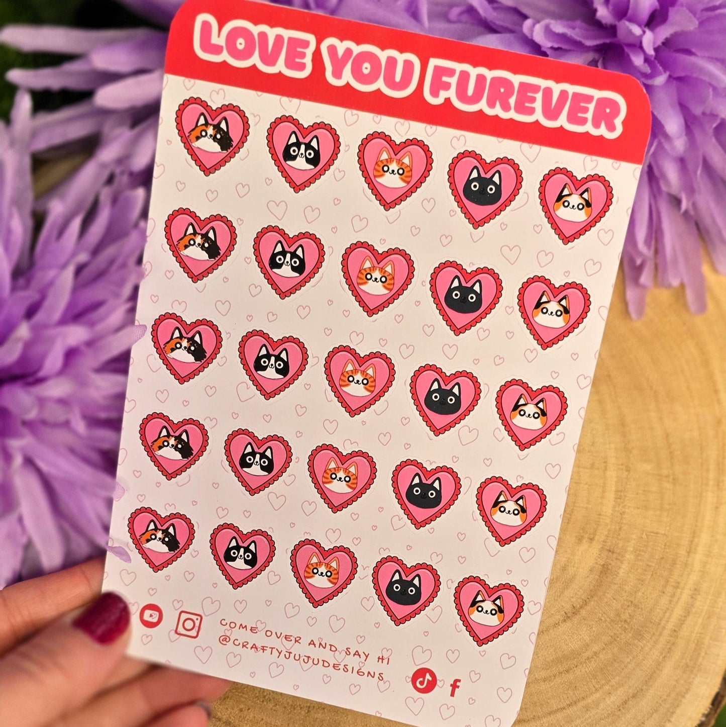 Sheet of heart-shaped stickers with cartoon characters held over purple flowers