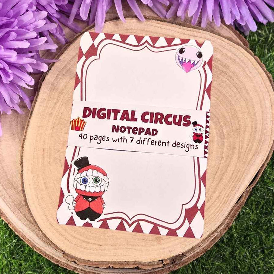 Digital Circus notepad with cartoon characters on a wooden surface with purple flowers.