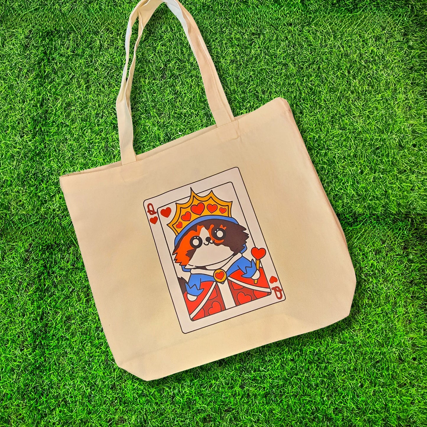 Beige tote bag with a playing card design featuring a dog on a grass background