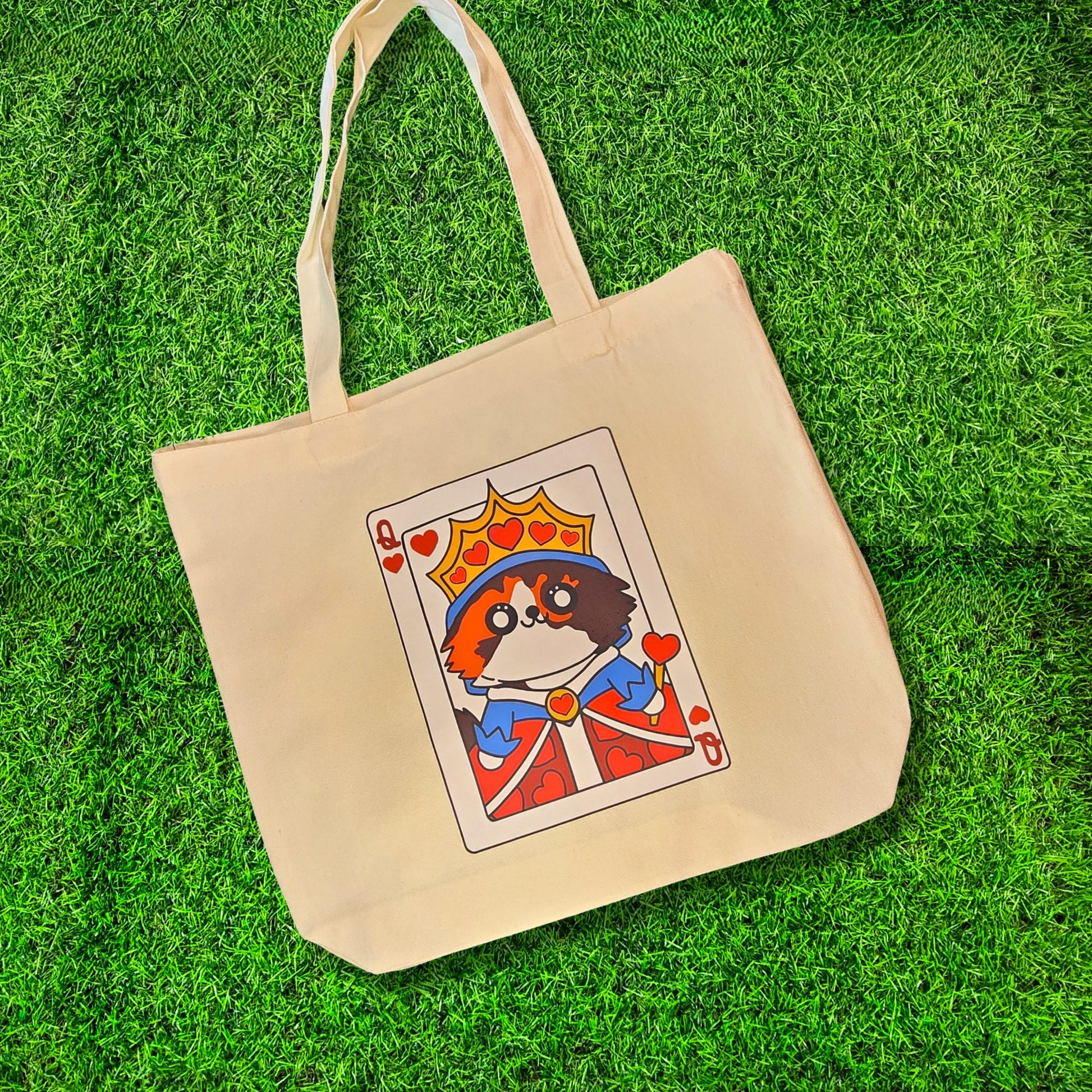 Beige tote bag with a playing card design featuring a dog on a grass background