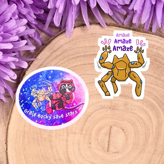 Two stickers on a wooden surface with purple flowers in the background