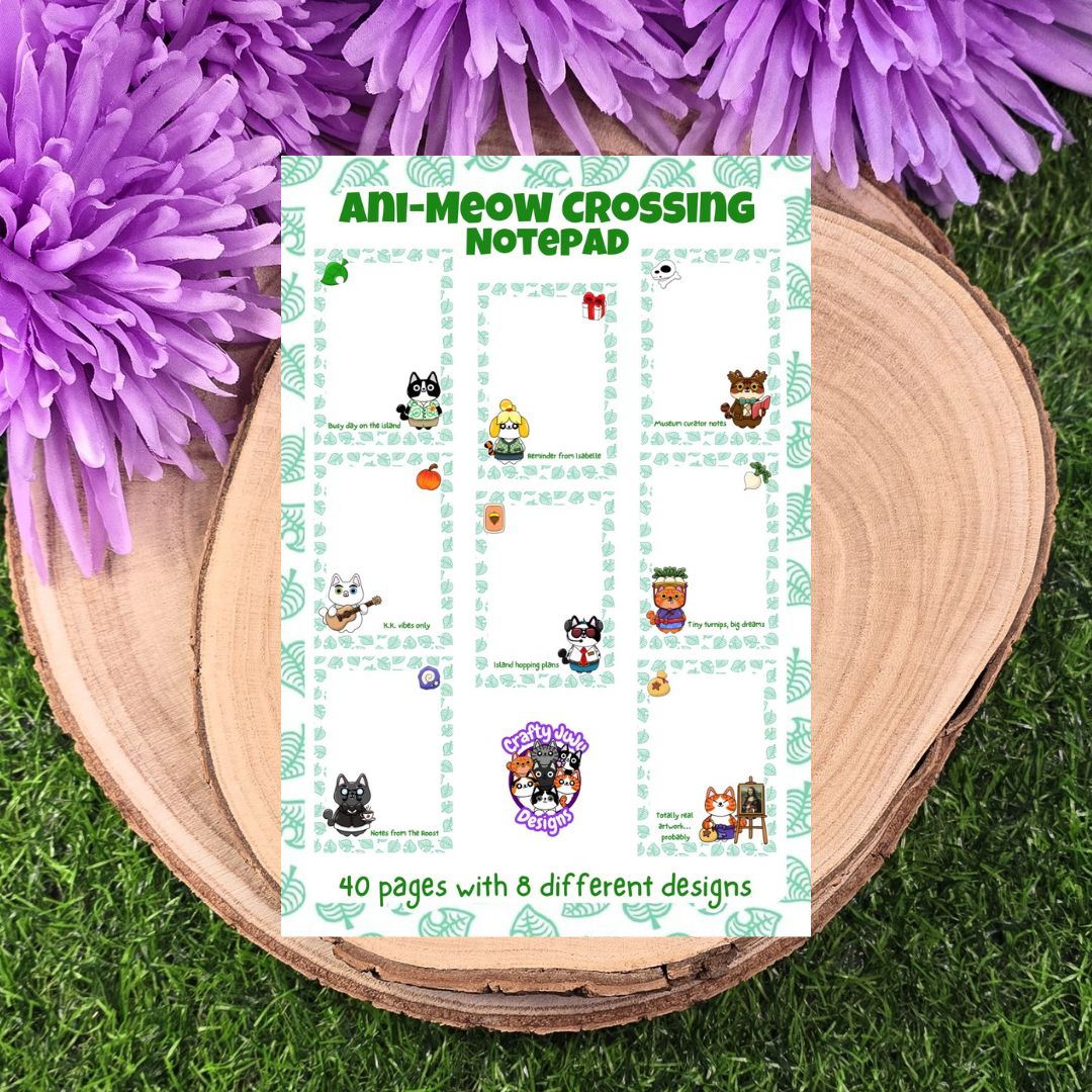 Notepad titled 'Ani-Meow Crossing' with cartoon characters on a wooden surface with purple flowers. 8 unique page designs and handmade in small batches