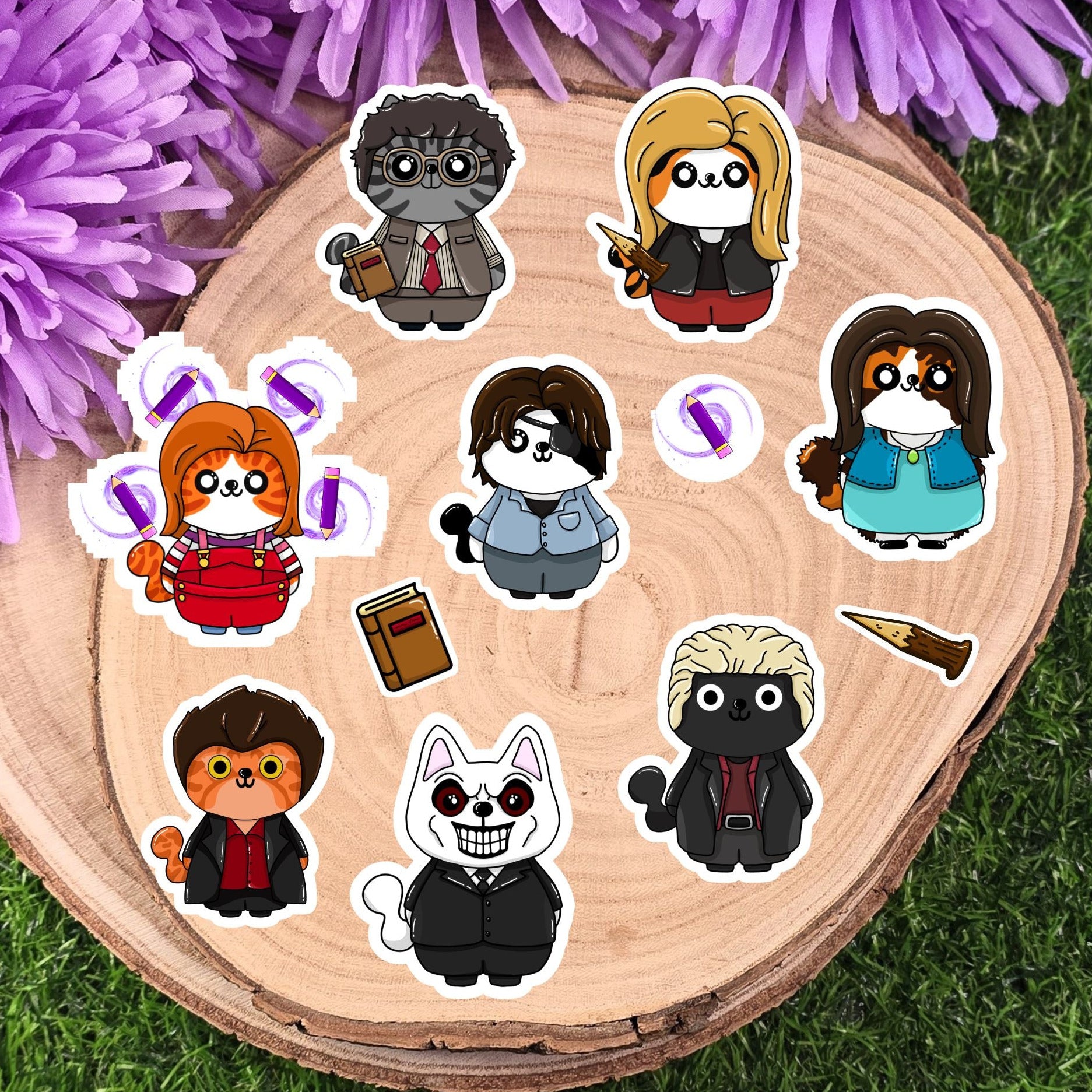 Set of buffy the vampire slayer cartoon cat character stickers on a wooden round board with purple flowers in the background.