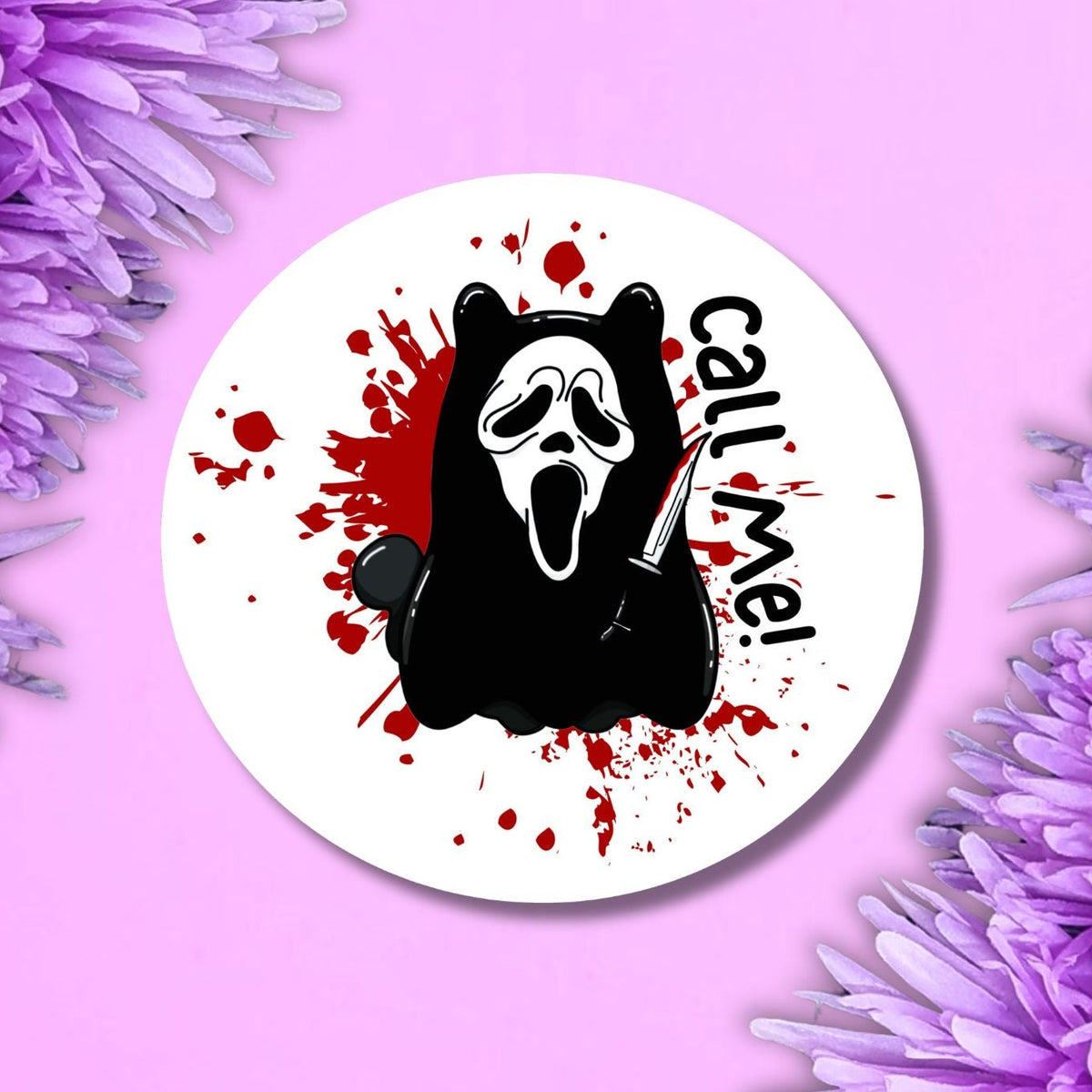 A round white badge featuring a black cartoon bear in a Ghostface-style mask with red blood splatters and the text 'Call Me' in black, displayed on a pink background with purple flowers in the corners.