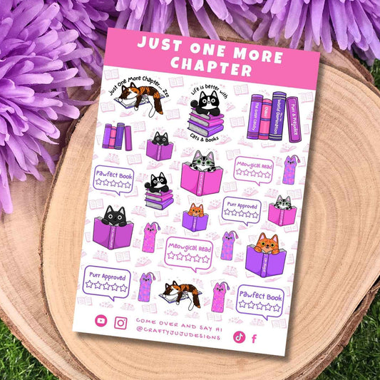A sticker sheet titled 'JUST ONE MORE CHAPTER' featuring cute illustrations of cats and books in shades of purple, pink, black, and white, styled on a wooden slice with purple flowers and green grass.