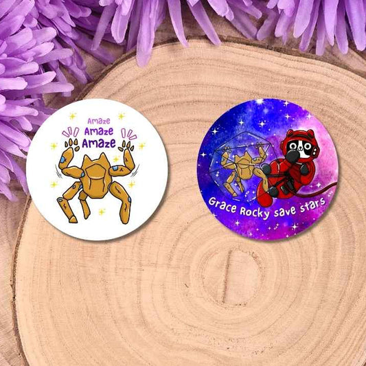 Two round printed button badges displayed on a wooden slice
