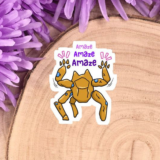 Sticker of a cartoon crab with 'Amaze' text on a wooden log with purple flowers.