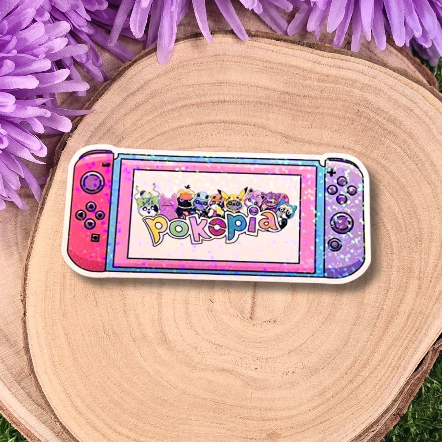 Colorful Pokopio gaming console on a wooden surface with purple flowers