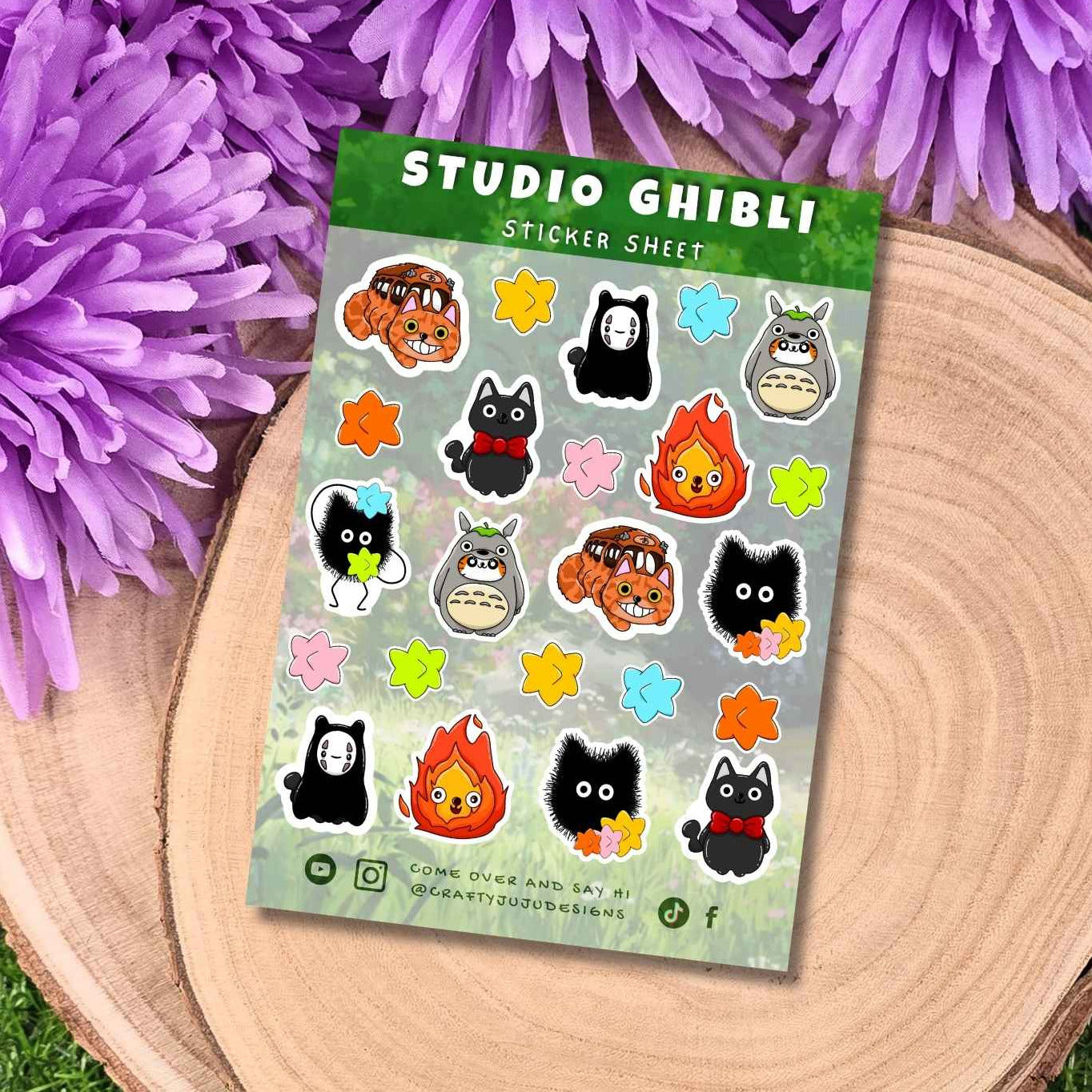 Studio Ghibli sticker sheet featuring characters from  Campfire, Zoot, Spirited Away, and Coco, displayed on a wooden slice with purple flowers and green grass.