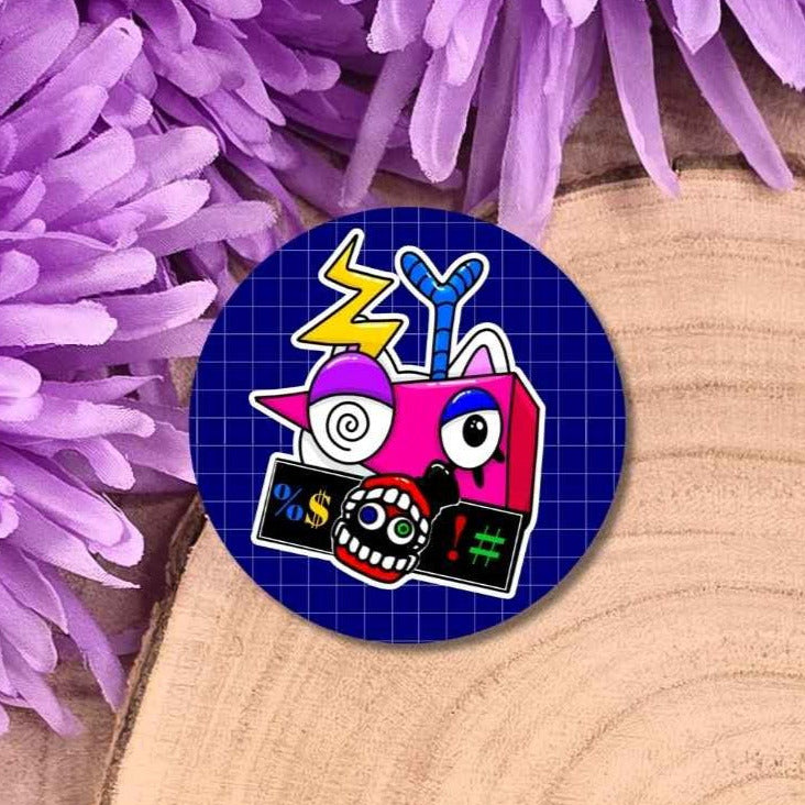 A round pin badge featuring a colorful cartoon robot design on a dark blue grid background, styled on a wooden slice with purple flowers.
